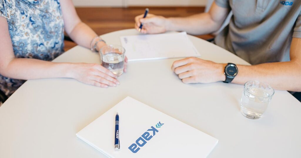 Ein KADA Berater und eine Athlet:in sitzen zum Beratungsgespräch an einem Tisch