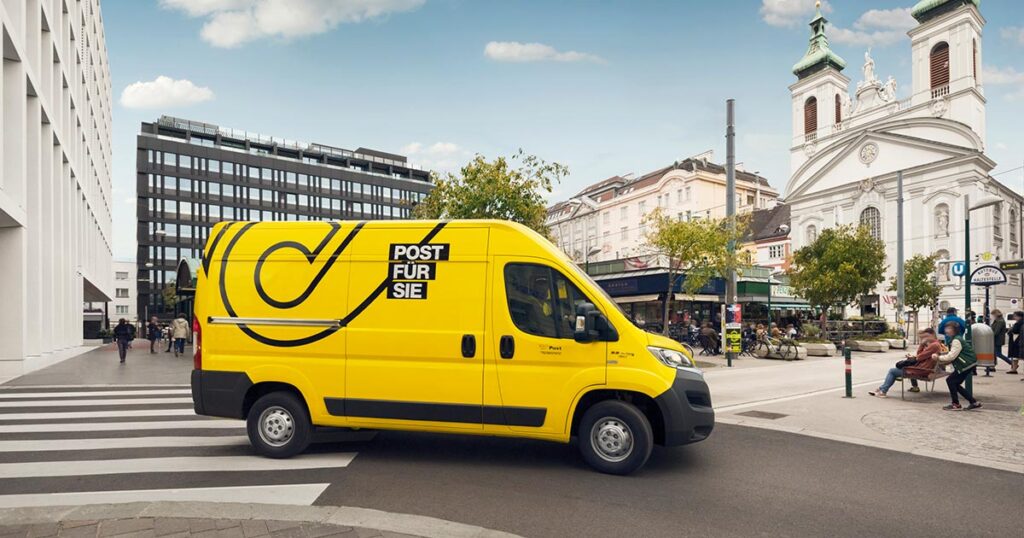 Ein Zustellfahrzeug der Post unterwegs durch ein Stadtzentrum