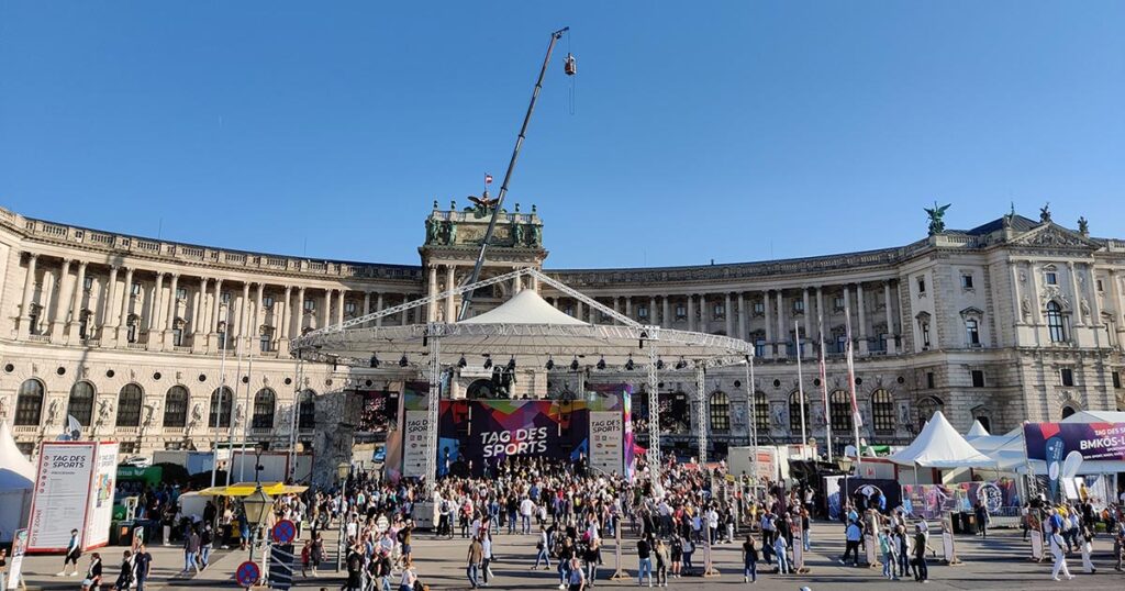 Zahlreiche Besucher:innen gehen am Wiener Heldenplatz von Ausstellungszelt zu Ausstellungszelt