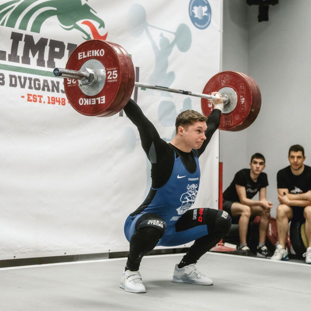 Dominik Čertov stemmt aus der Hocke eine Gewichtstange hoch