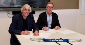 Wolfgang Mayrhofer und Herwig Grabner unterzeichnen an einem Schreibtisch sitzend die Kooperationsvereinbarung