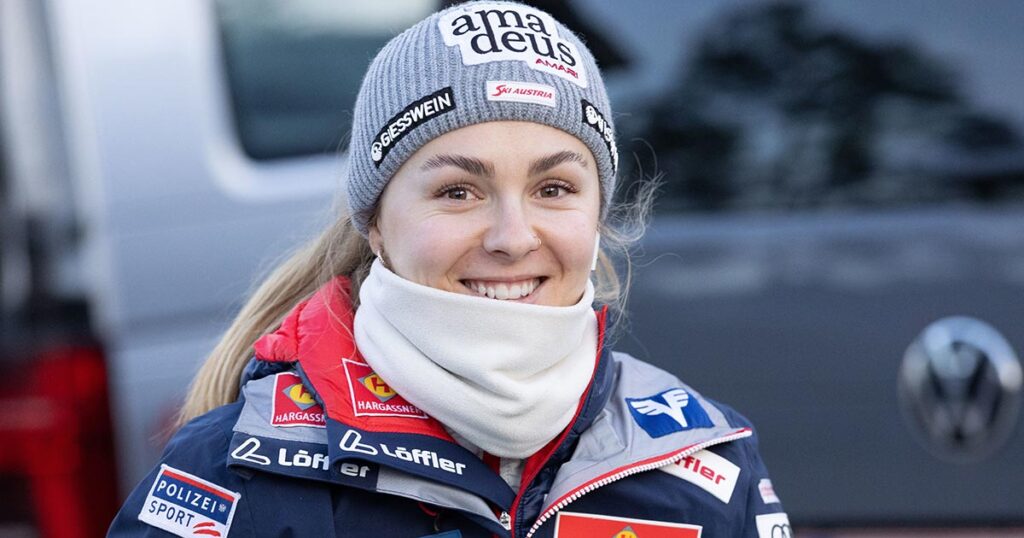 Skispringerin Chiara Kreuzer lächelt in voller ÖSV-Montur in die Kamera